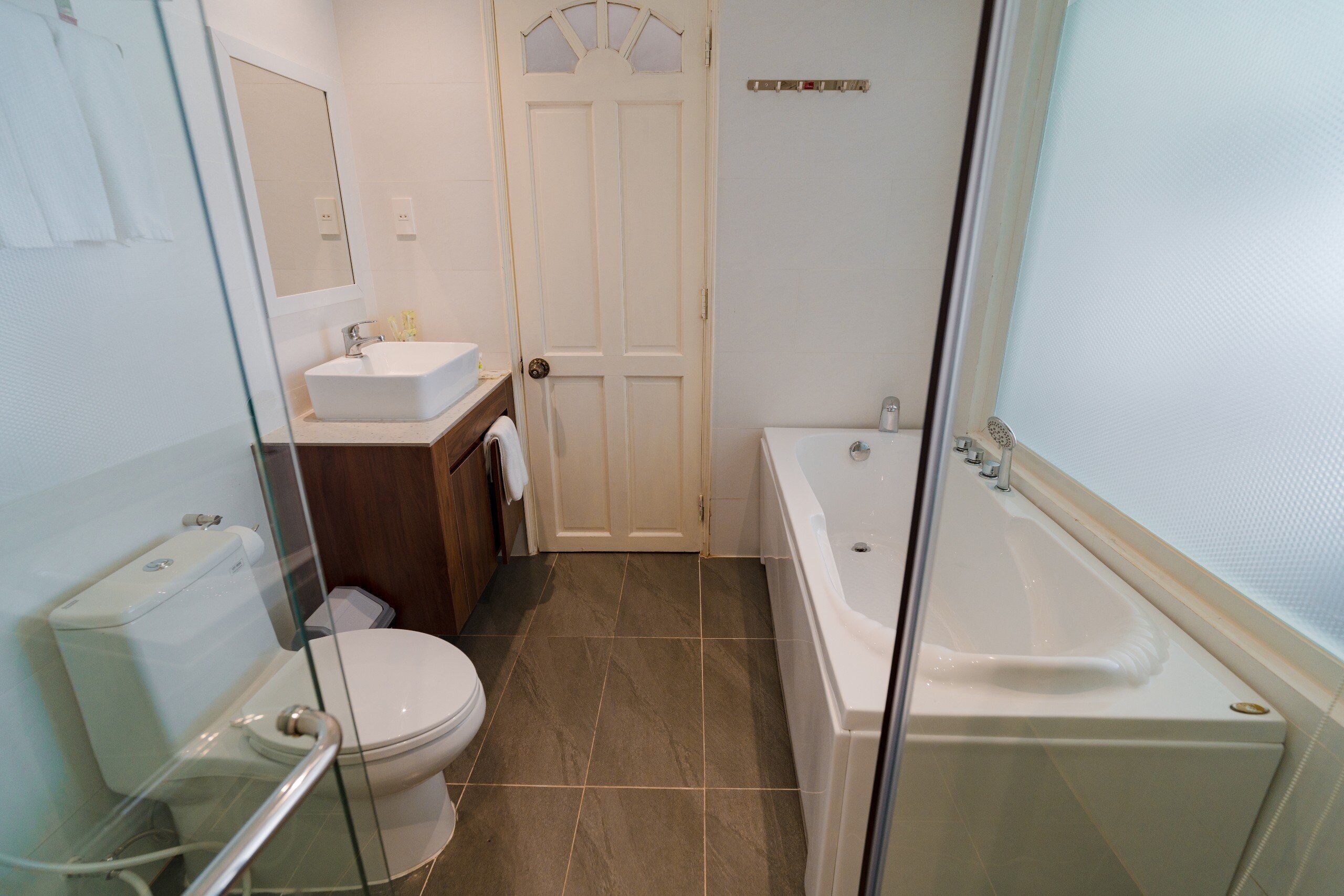 A bathroom with a toilet, sink, and bathtub.