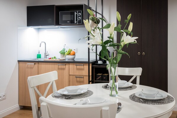 Enjoy meals in this kitchen with a dining table, microwave, and sink.