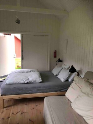 Ein Schlafzimmer mit Bett, Nachttischen, einer Tür und einem Fenster.