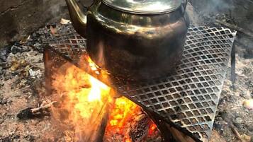 A metal pot over an open fire on a metal grate.