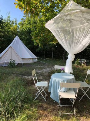 Una carpa, una mesa con sillas y un toldo.