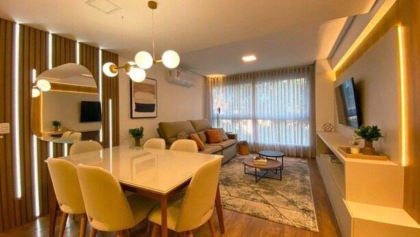 Uma sala de estar moderna com área de refeições, um sofá e uma televisão.
