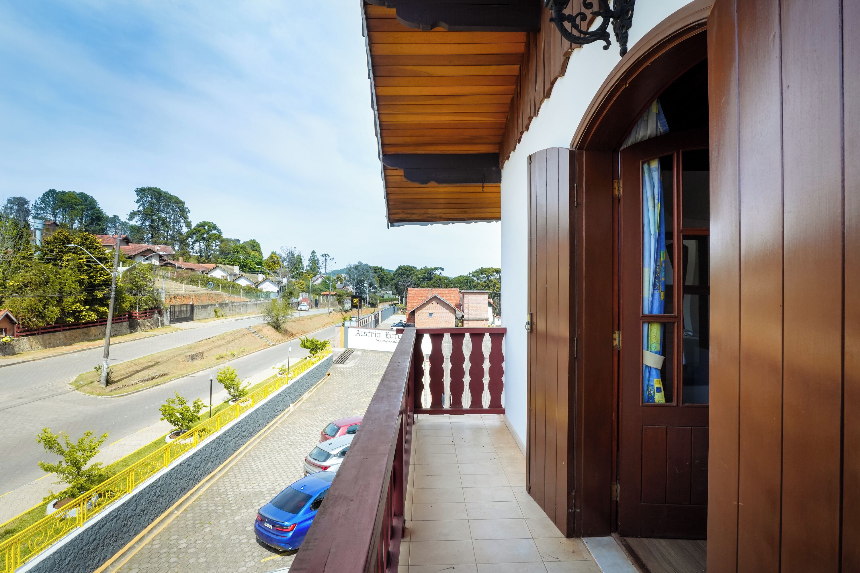 A balcony with a view of a street and parked cars.