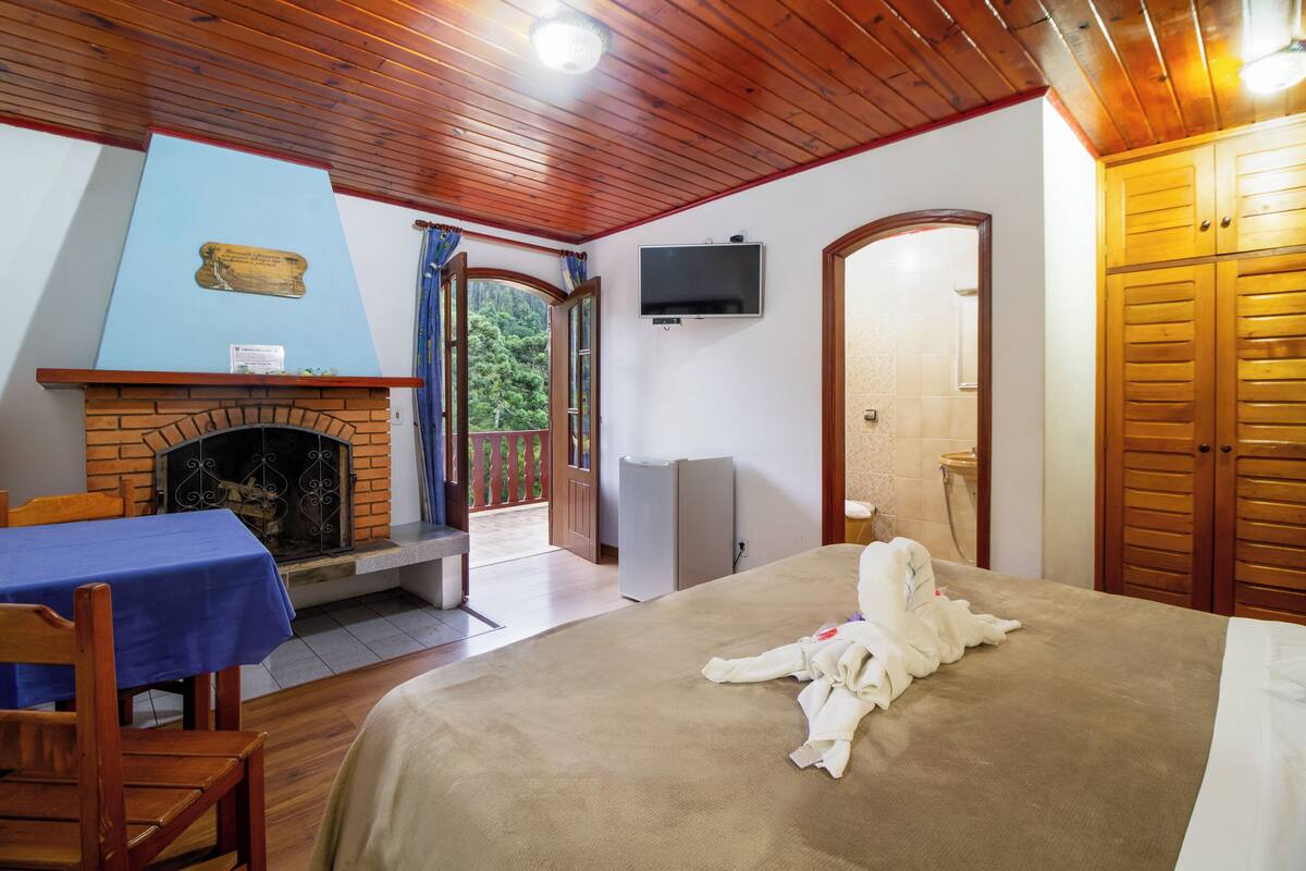 Ein Schlafzimmer mit Kamin, Fernseher und Holztür.
