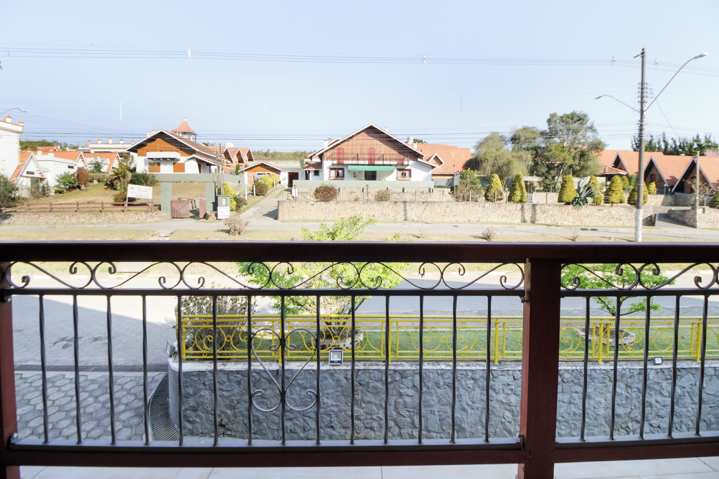 A residential area with houses, a stone wall, and a metal fence.