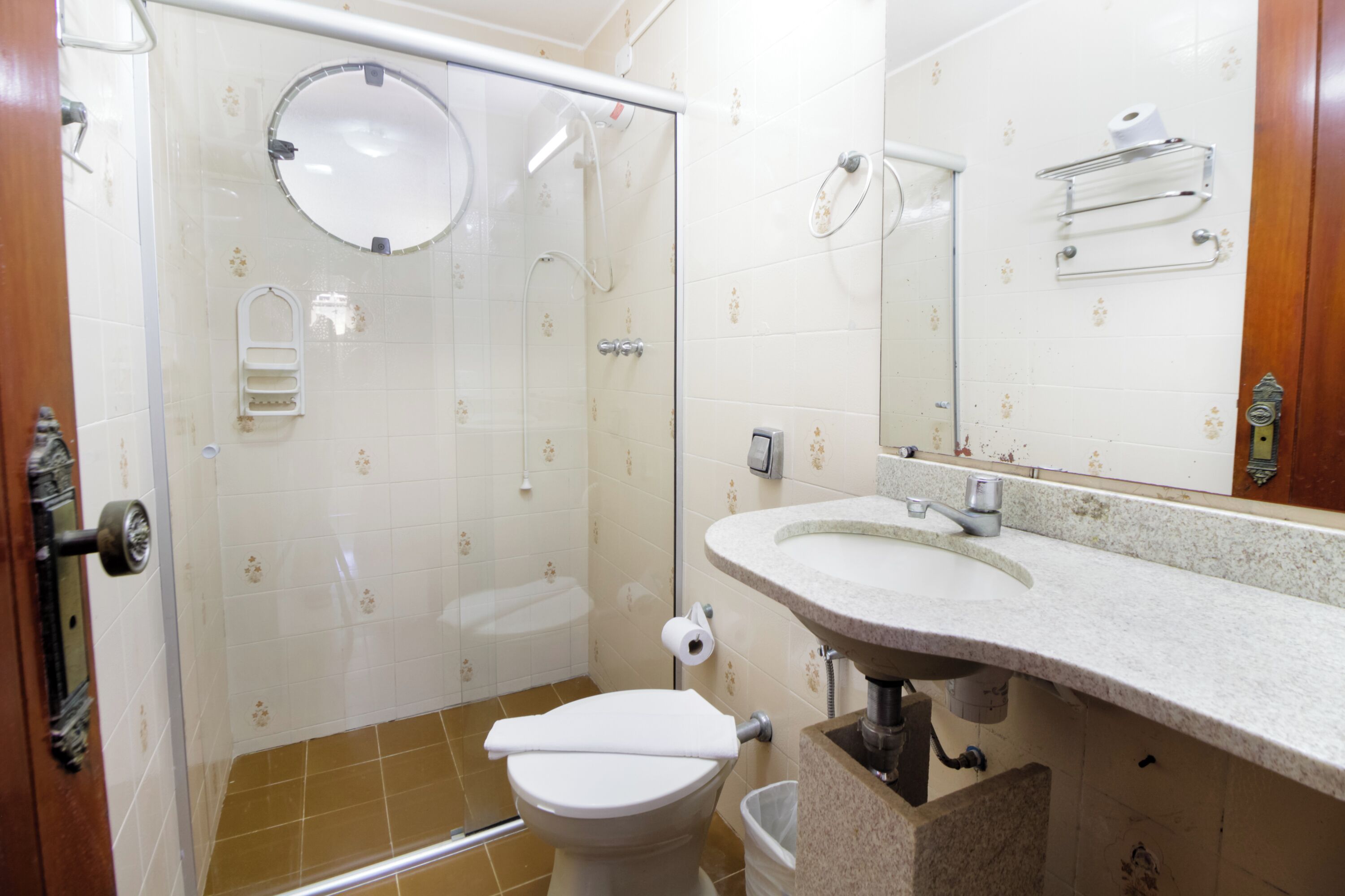Une salle de bain équipée d’une douche, de toilettes, d’un lavabo et d’un miroir.