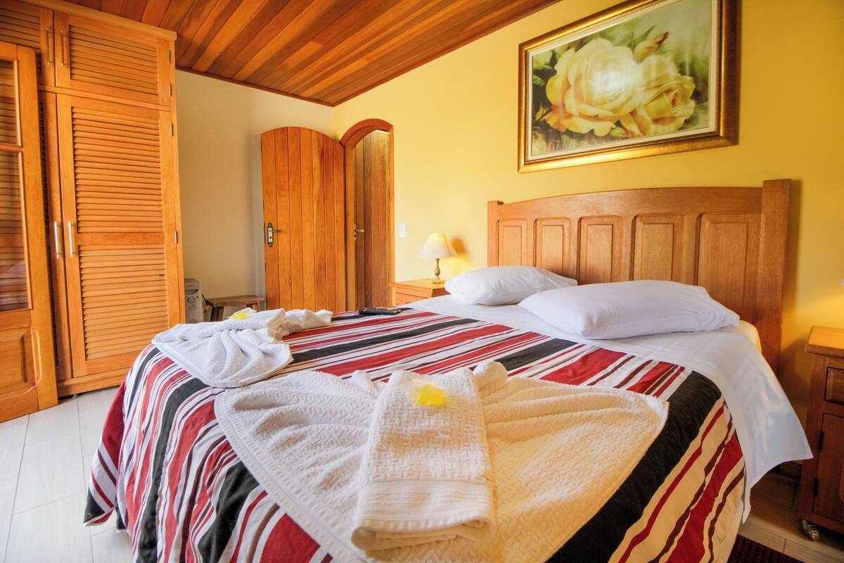 Ein Hotelzimmer mit Bett, Holzschrank und einem Bild an der Wand.