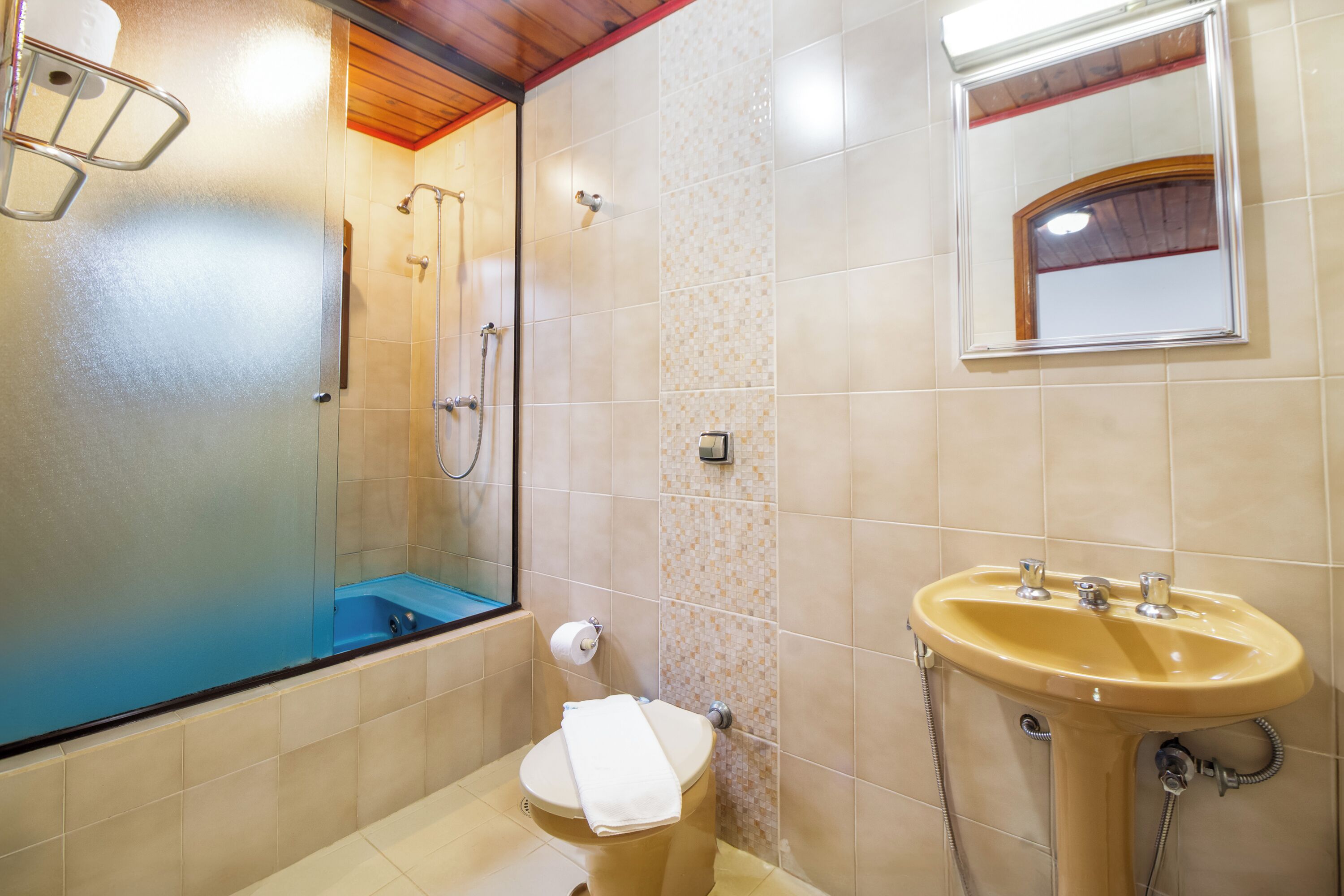A bathroom with a glass-enclosed shower, a toilet, and a sink.