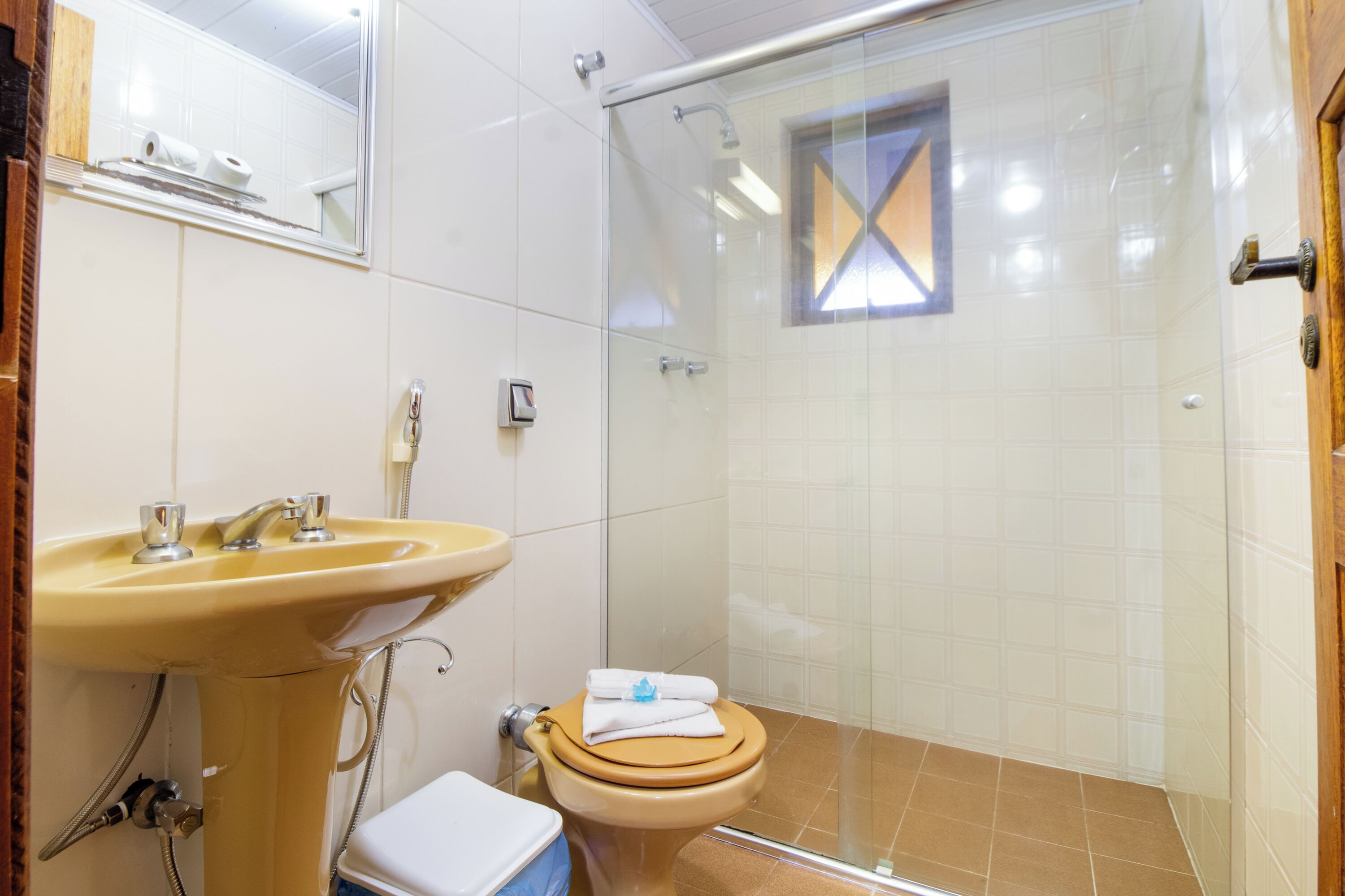 A bathroom with a sink, toilet, and glass shower enclosure.