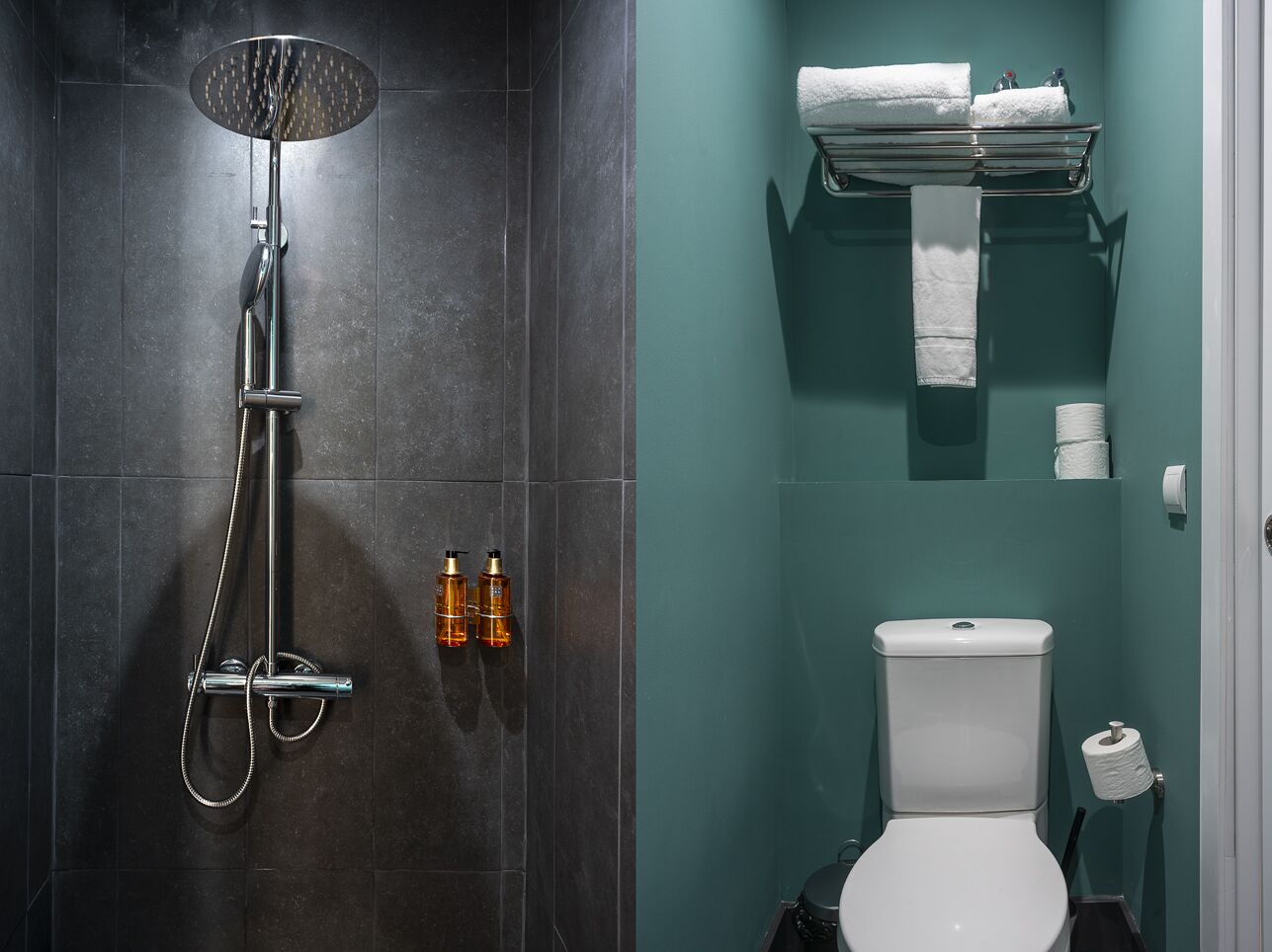 A bathroom with a shower, toilet, and towel rack.