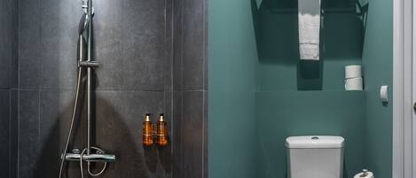 A bathroom with a shower, toilet, and towel rack.