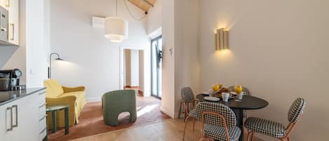 A modern kitchen with a dining area featuring a round table and checkered chairs.