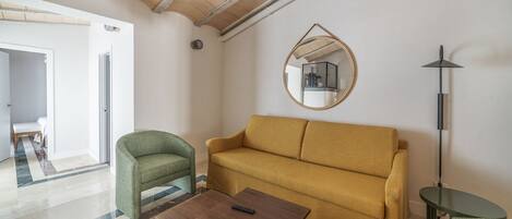 Una sala de estar con un sofá, dos sillones, una mesa de centro y una lámpara de pie.