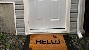 A white front door with a glass panel and a doormat with "HELLO" written on it. - Cozy basement apartment suite, beautiful Paradise! (Paradise)