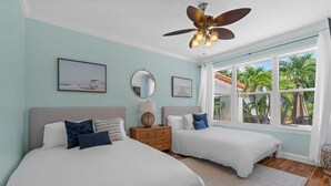 A bedroom with two beds, a ceiling fan, and a large window with a view of palm trees. - Heated Pool Beach Miramar Villa by Rovetravel (West Palm Beach)