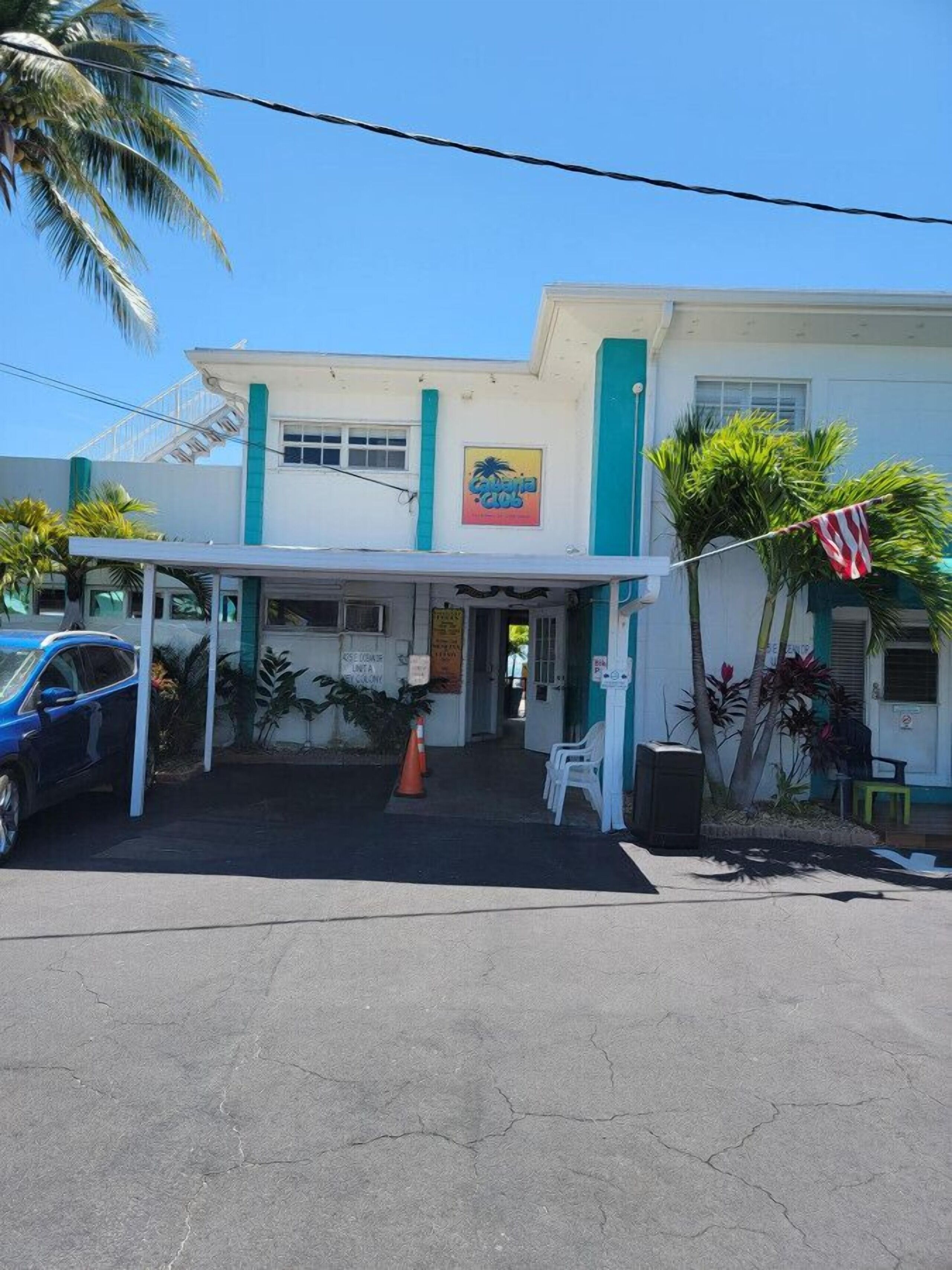 A two-story building with a white facade and teal accents. There is a sign on the front that reads "Café 200".