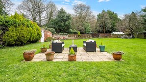 A patio with outdoor furniture and potted plants.