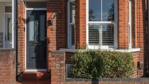 A brick house with a dark front door, a bay window with shutters, and a small hedge in front. - Pass the Keys | Stunning 3 Bedroom Townhouse in Central St Albans (St Albans)