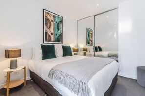 Retreat to a bedroom that promises restful nights, set with luxurious linens and a queen bed.