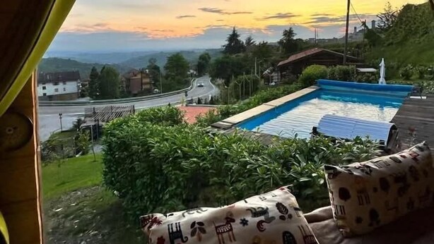 Ein Zimmer mit einem großen Bogenfenster mit Blick auf einen Swimmingpool und eine Straße.
