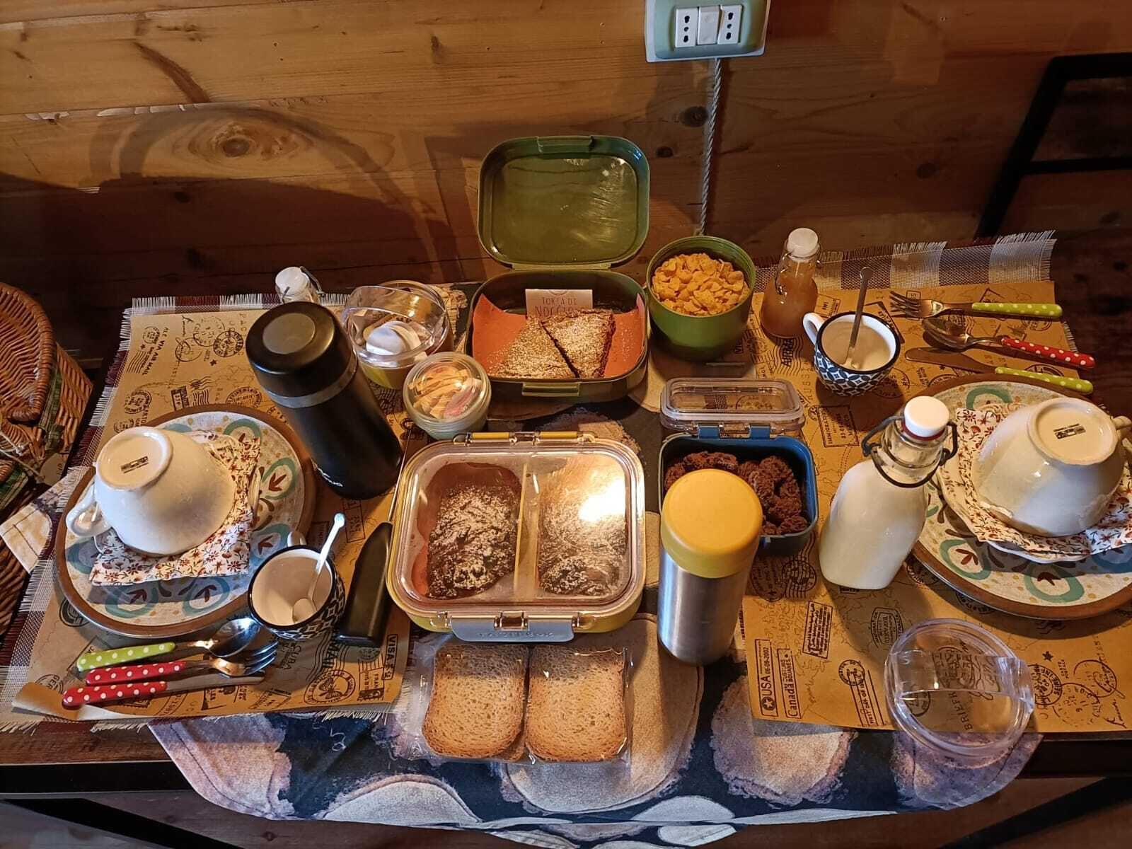 A breakfast buffet with various food items and utensils on a table.