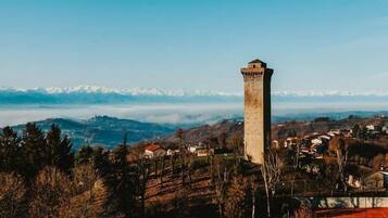 A tower in a hilly landscape with a clear sky.