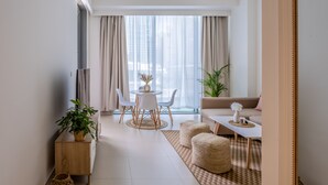 Un salon moderne comprenant un canapé, une table basse et un coin repas avec des chaises et une table.