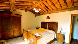 Un dormitorio tradicional con una cama de madera, una mesita de noche y un armario.