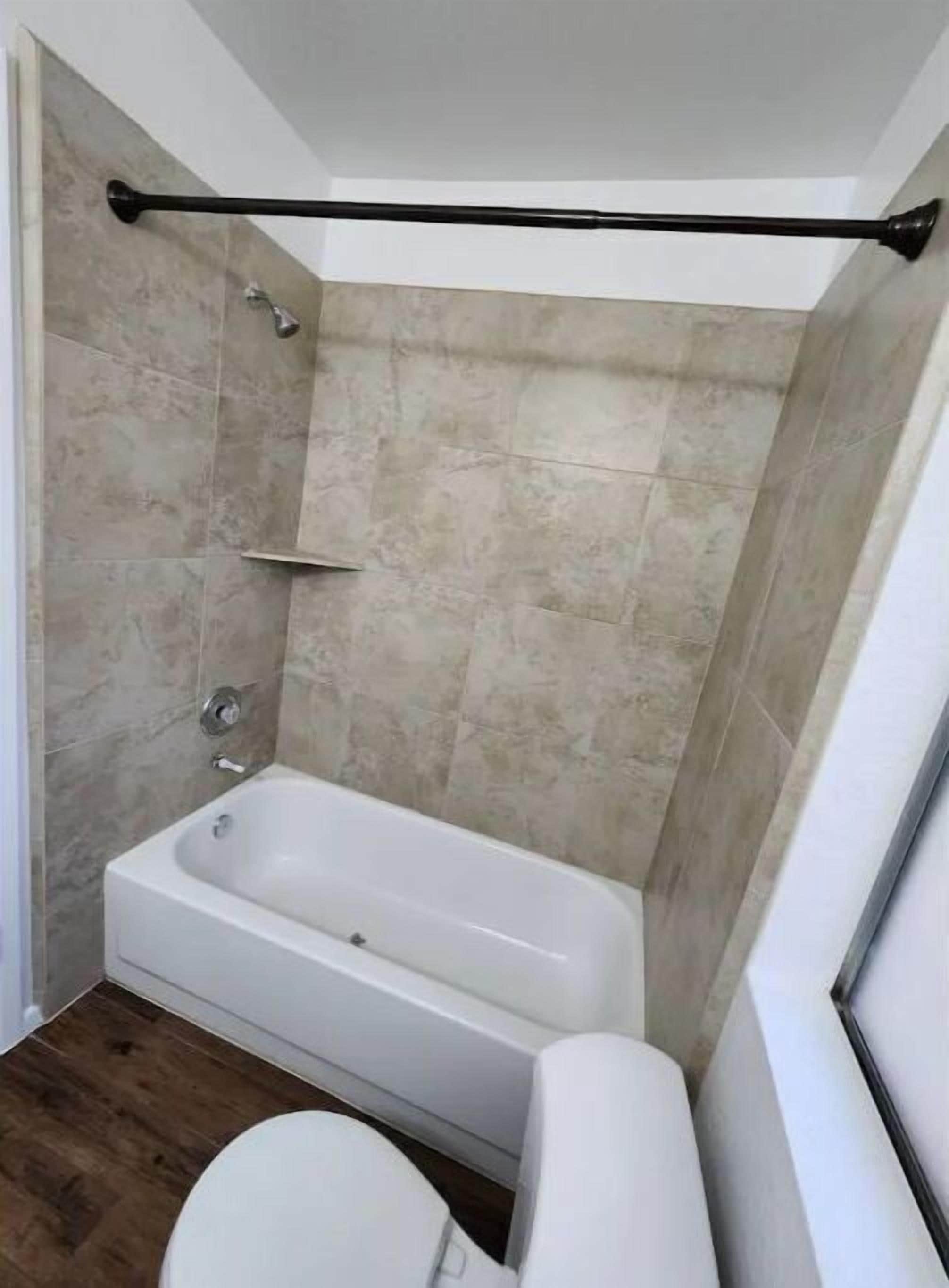Un bagno con vasca, toilette e zona doccia.