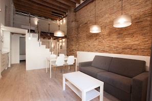 Un intérieur moderne comprenant un coin repas, un canapé et un escalier.