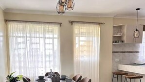 Un comedor con una mesa rectangular, seis sillas y un tapete estampado.