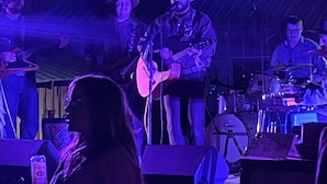 A band performing on stage with a drum set and a keyboard in the background. - The Gold Mine Hotel (Idaho City)