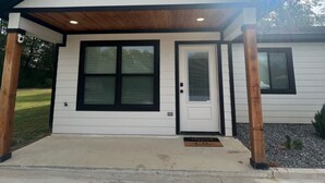 A single-story house with a front porch, a wooden door, and a small front yard.