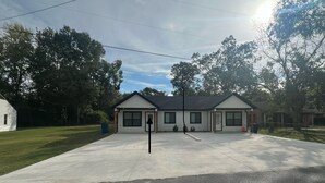A single-story building with a gabled roof, a front porch, and a driveway.
