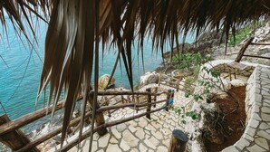 A stone pathway leading to a wooden deck overlooking a body of water. - Negril Bungalow Paradise overlooking cliffs with Private Snorkeling Entrance. (Hanover Parish)