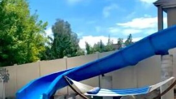 Une piscine avec un toboggan bleu.