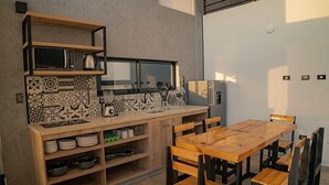 Une cuisine compacte avec une table et des chaises en bois, un four à micro-ondes et un réfrigérateur.