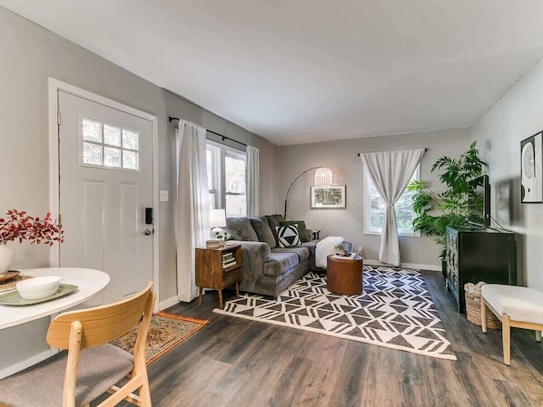 Un salon moderne avec un canapé, une table basse et un tapis à motifs.