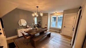 Una cocina moderna con una mesa de comedor de madera, bancos y una lámpara de araña.