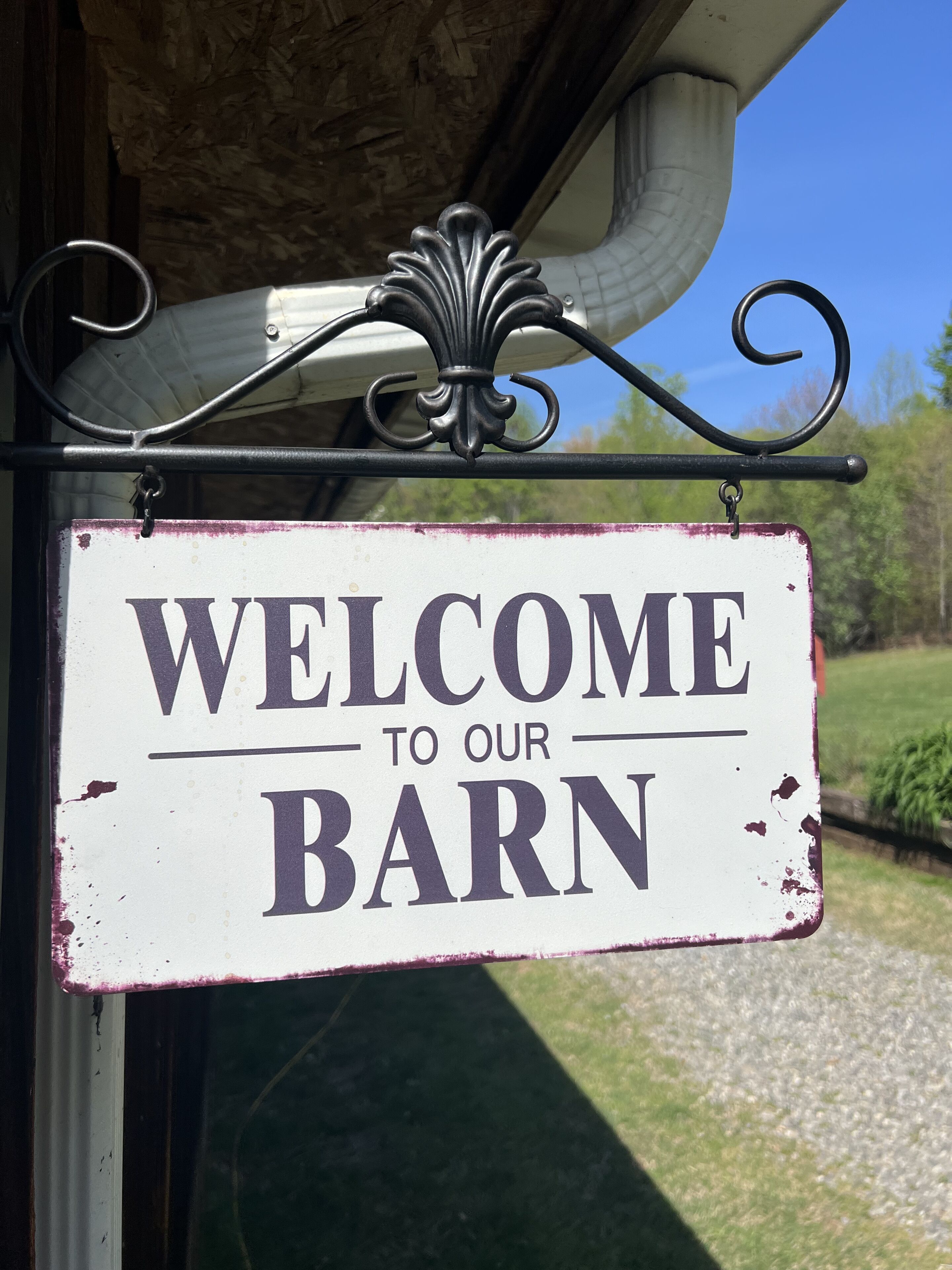 A rustic welcome sign for a barn.
