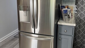 A stainless steel refrigerator with a freezer compartment, a built-in ice maker, and a water dispenser.