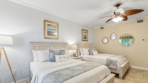 A bedroom with two beds, a ceiling fan, and a nightstand with a lamp. - Spacious,Ultimate Comfort,Privacy,AIP Resort . (Fernandina Beach)