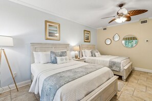 A bedroom with two beds, a ceiling fan, and a nightstand with a lamp. - Spacious,Ultimate Comfort,Privacy,AIP Resort . (Fernandina Beach)