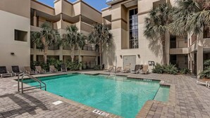 A swimming pool with a 6 ft depth marker, surrounded by lounge chairs and palm trees. - Spacious,Ultimate Comfort,Privacy,AIP Resort . (Fernandina Beach)