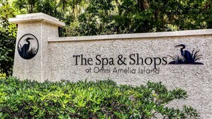 Une enseigne pour « The Spa & Shops at Omni Amelia Island », avec un logo représentant un oiseau et une plante.