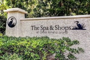 Opastekyltti, jossa lukee: ”The Spa & Shops at Omni Amelia Island”, ja jossa on logon kuvana lintu ja kasvi.