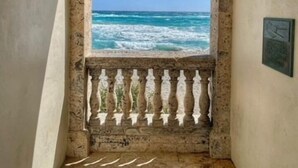 Un arco de entrada que da a un balcón con vistas al mar.
