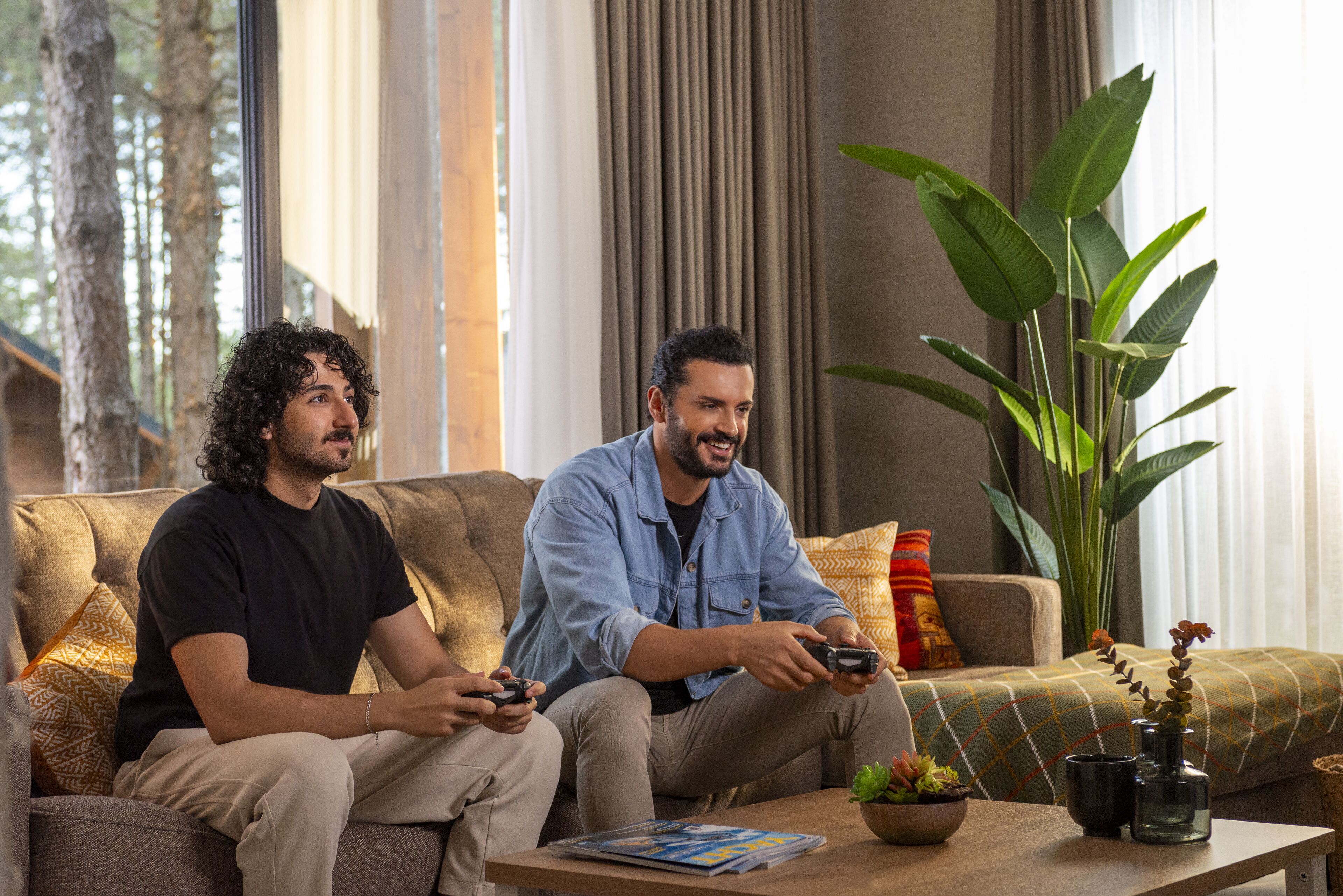 Two people sitting on a sofa playing video games.