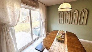 A dining area with a wooden table, bench, and decorative plants. - Westport Beach Hideout (West Fargo)
