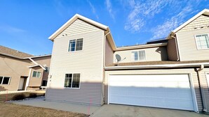 A two-story residential building with a garage, a satellite dish, and a clear sky. - Westport Beach Hideout (West Fargo)